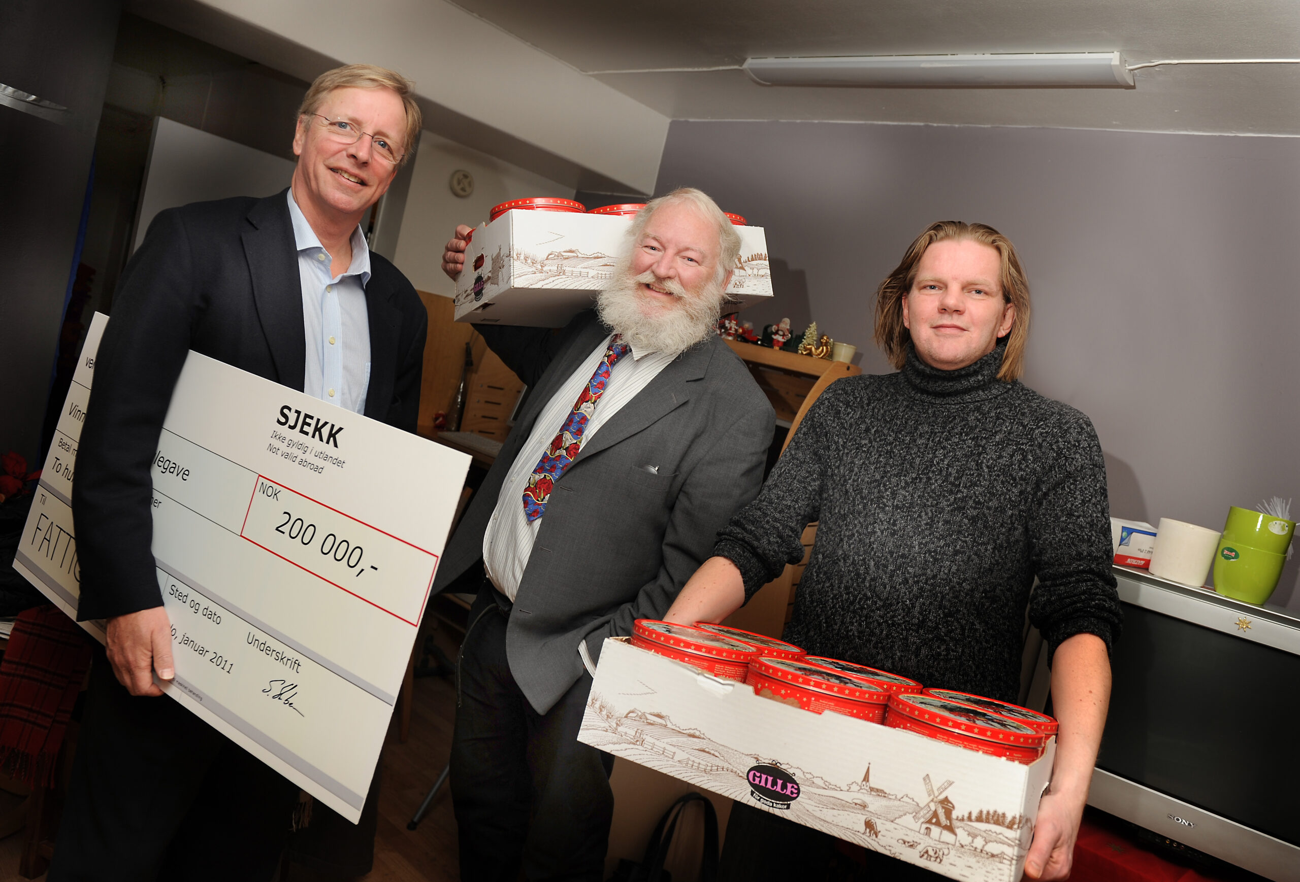 Fattighuset fikk julegavesjekken fra Ventelo. Fattighusets styreleder Gregory Starr (i midten), presseansvarlig Erling Westenvik til høyre og Stig Herbern, adm.dir. i Ventelo til venstre. Foto: Marianne Otterdahl-Jensen